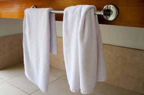 Zwei weiße Handtücher auf einer Handtuchhalterung